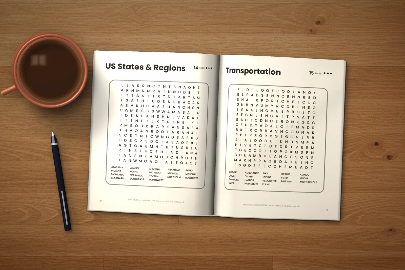 Hard Word Search for Adults lying open on a wooden table, showing two word searches (“US States & Regions” and “Transportation”), next to a cup of coffee and a pen