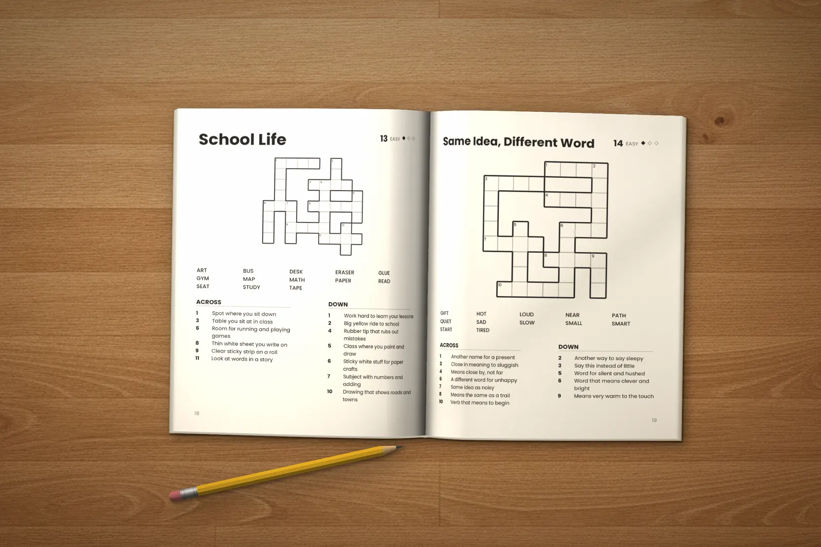 Crossword Puzzles for Kids: Easy, Medium & Hard lying open on a wooden table, showing two crosswords (“School Life” and “Same Idea, Different Word”), next to a yellow pencil
