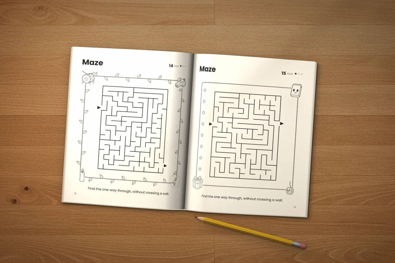 Mazes for Kids: Easy, Medium & Hard lying open on a wooden table, showing two easy mazes, next to a yellow pencil